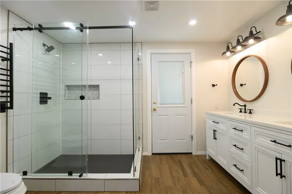 a bathroom with a double vanity sink mirror and shower