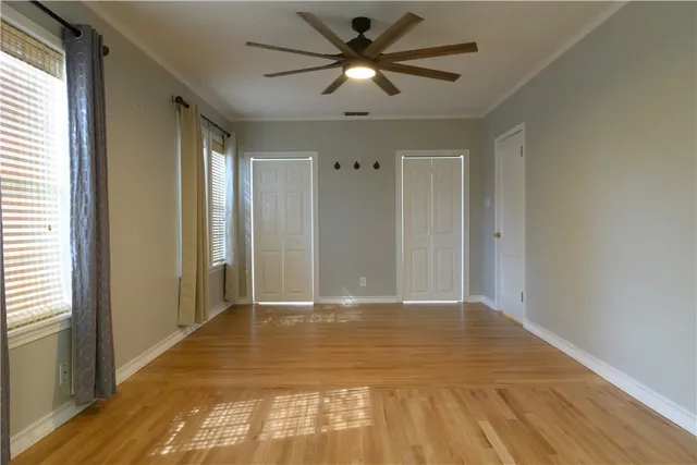 a view of a livingroom with a chandelier fan and wooden floor