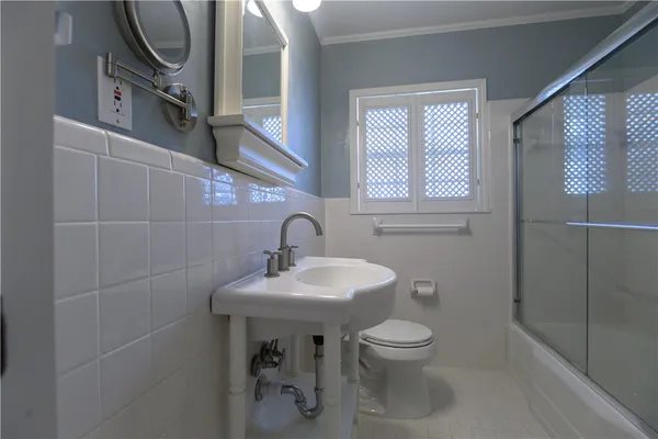 a bathroom with a sink a toilet and a mirror