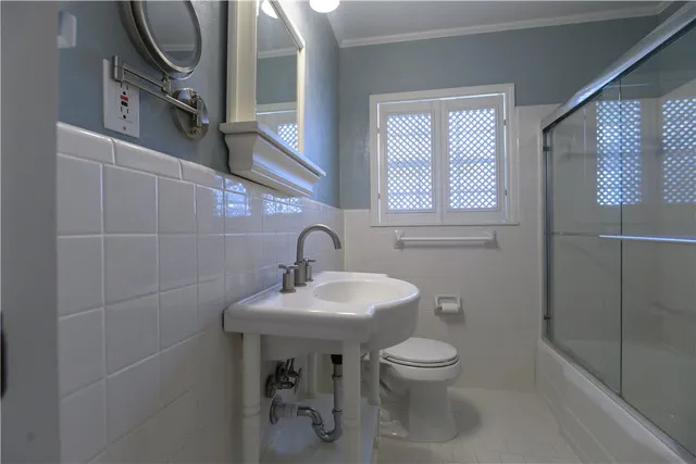 a bathroom with a sink a toilet and a mirror