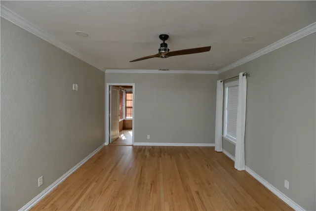 a view of empty room with wooden floor