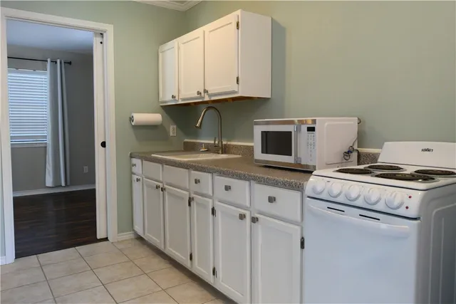 a kitchen with granite countertop a stove top oven microwave and cabinets
