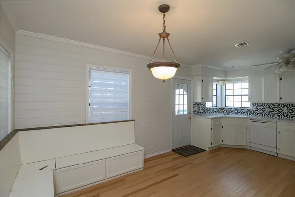 a view of empty room with wooden floor and window