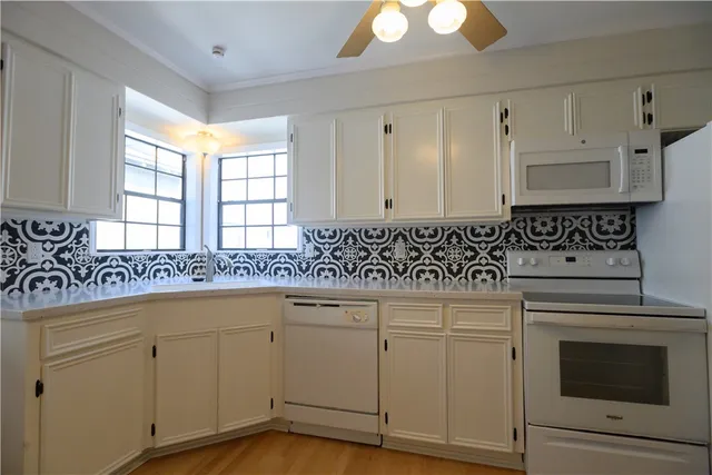 a kitchen with white cabinets and sink