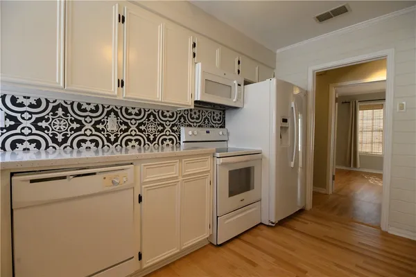 a kitchen with white cabinets and white appliances