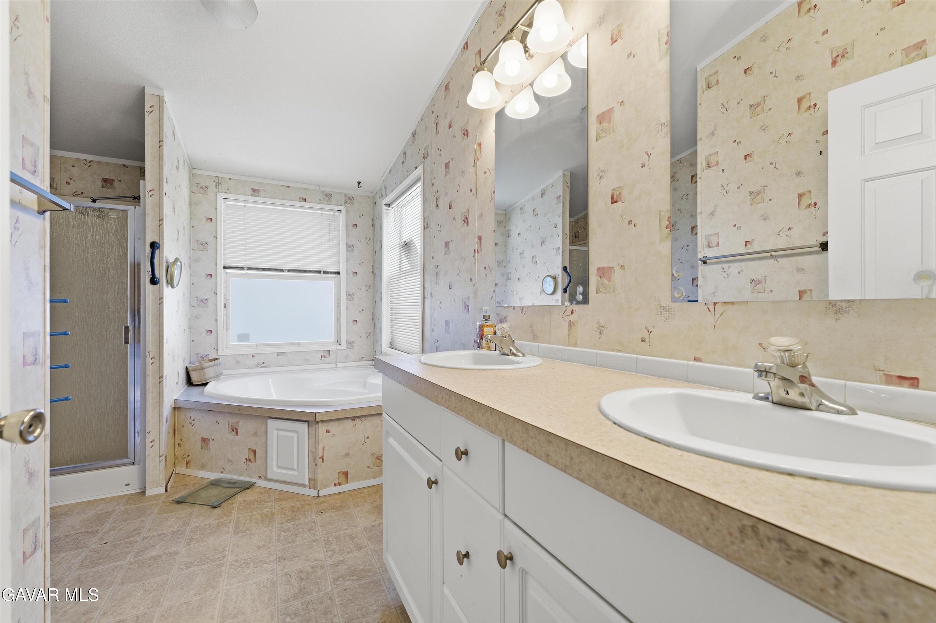 1900 Sandra Way Rosamond, CA 93560 - Photo 13 of 20 a bathroom with a sink double vanity granite tub shower and a mirror