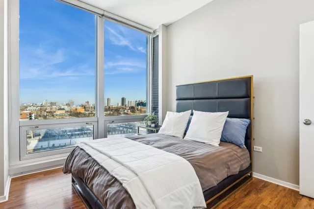 a bedroom with a bed and a large window