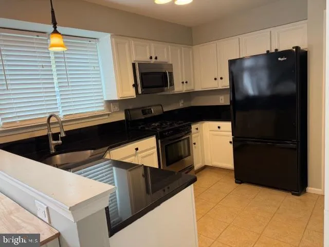 a kitchen with stainless steel appliances granite countertop a refrigerator and a stove