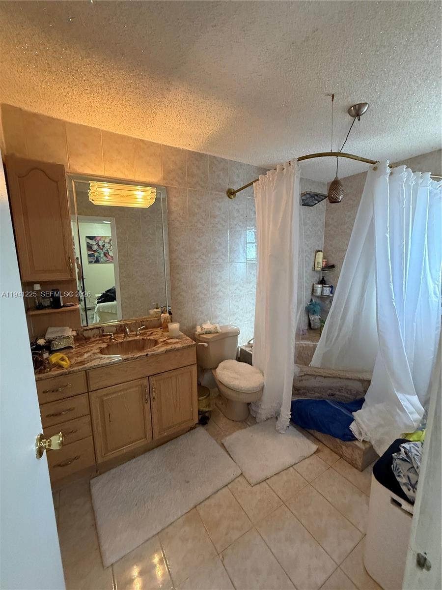 1950 West 54th Street, Unit 409 Hialeah, FL 33012 - Photo 16 of 26 a bathroom with a granite countertop sink a toilet and a mirror