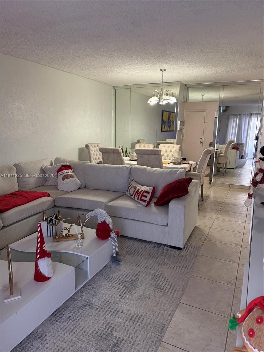 1950 West 54th Street, Unit 409 Hialeah, FL 33012 - Photo 10 of 26 a living room with furniture and a chandelier