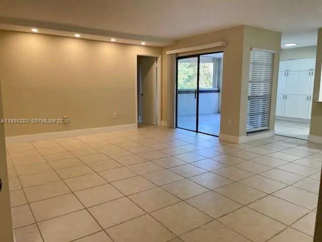 an empty room with a fireplace and large windows