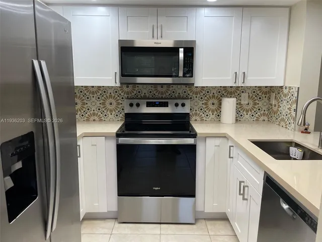 a kitchen with granite countertop a stove and a microwave
