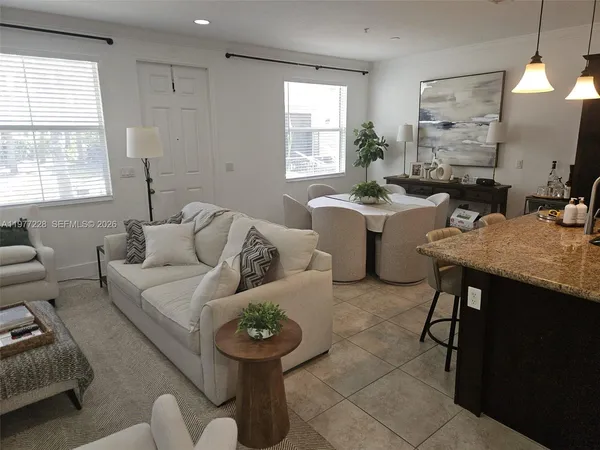 a living room with furniture a window and a flat screen tv