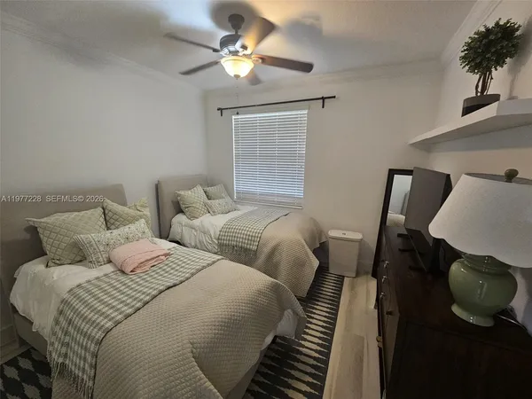 a bedroom with two beds and a chandelier