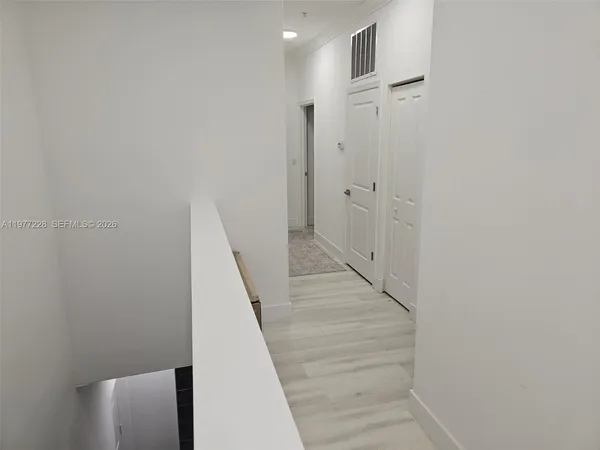 a view of hallway with stairs and wooden floor
