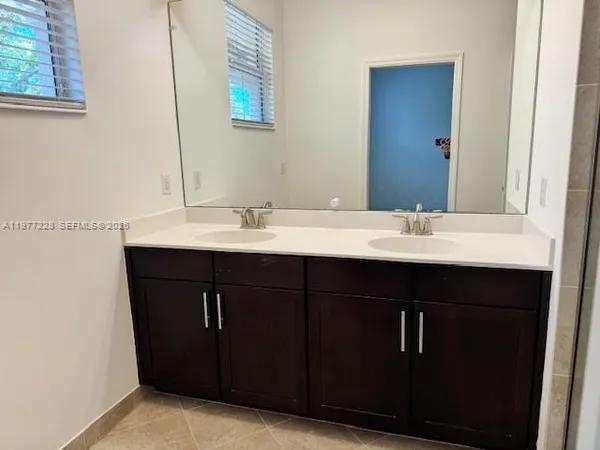 a bathroom with a double vanity sink and a mirror