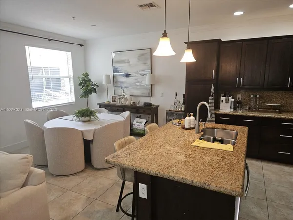 a kitchen with a table chairs sink and cabinets