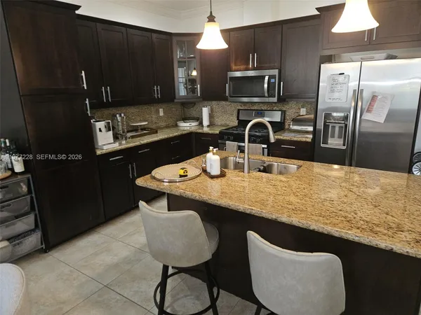 a kitchen with stainless steel appliances granite countertop a sink refrigerator and microwave