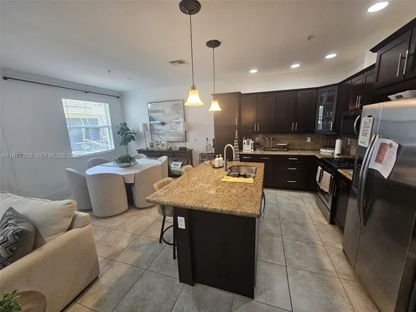 a kitchen with kitchen island a sink table and chairs