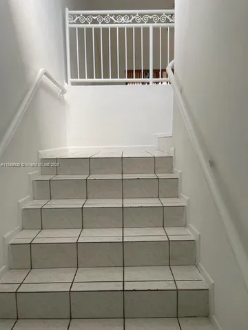 a view of staircase with white walls and a window