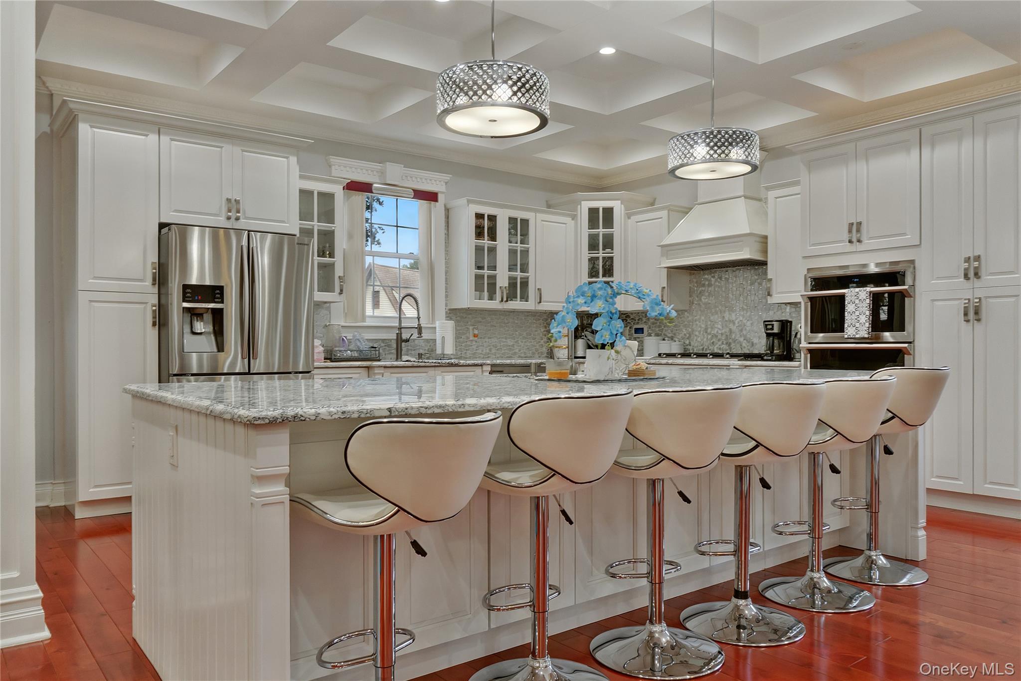 193-19 109th Road Queens, NY 11412 - Photo 3 of 27 a kitchen with stainless steel appliances granite countertop a dining table chairs refrigerator and microwave