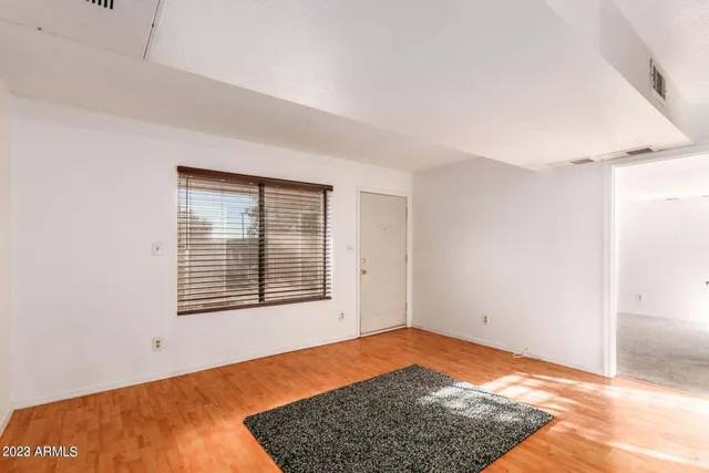 a view of empty room with wooden floor and window