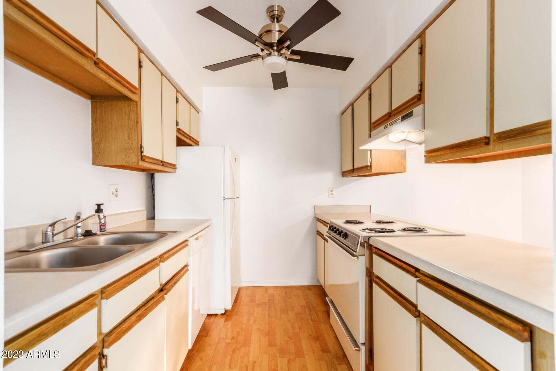 1440 North Idaho Road, Unit 1036 Apache Junction, AZ 85119 - Photo 6 of 13 a kitchen that has a sink and a stove