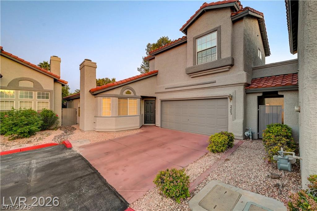 Spanish tile roof accents and a multi-level design define this stucco exterior.