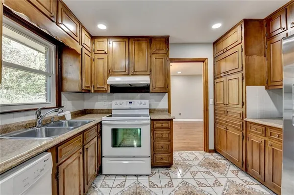 a kitchen with stainless steel appliances granite countertop a sink stove and refrigerator