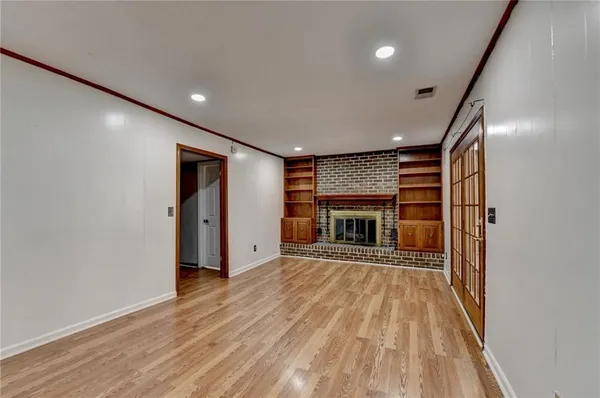 an empty room with wooden floor and a fireplace