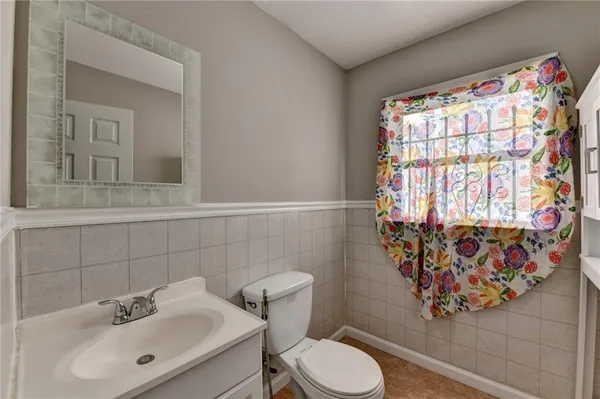 a bathroom with a toilet sink and mirror