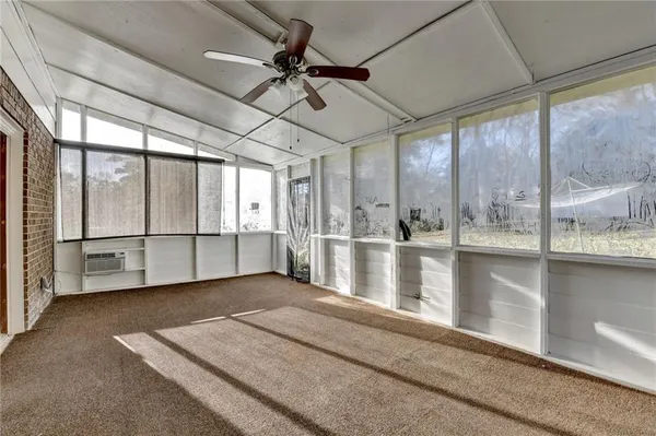 a view of a livingroom with a ceiling fan and window