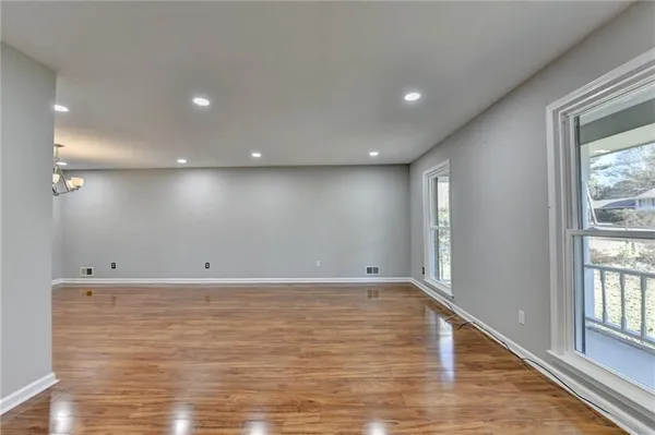 a view of a room with wooden floor and windows