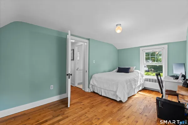 a bedroom with a bed and wooden floor