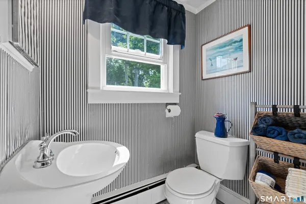 a bathroom with a toilet a sink and a window