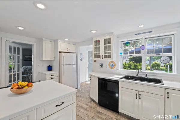a kitchen with stainless steel appliances granite countertop a sink and a refrigerator