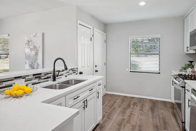 a kitchen with cabinets appliances and a sink