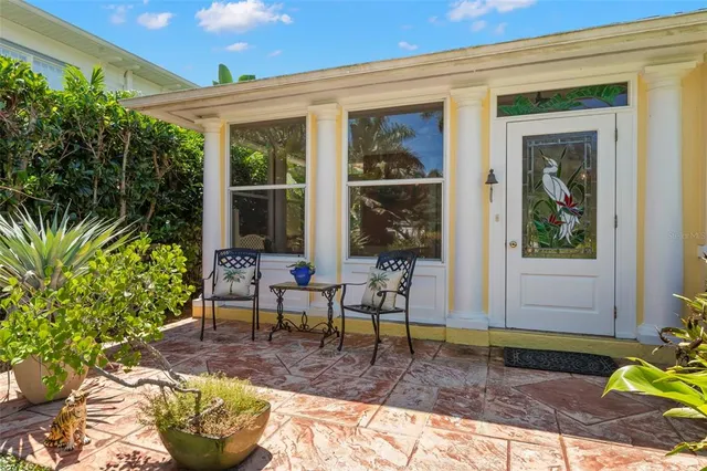 a view of a patio with table and chairs and potted plants with wooden fence