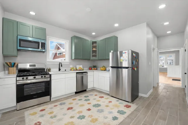 a kitchen with stainless steel appliances a stove a sink and a refrigerator