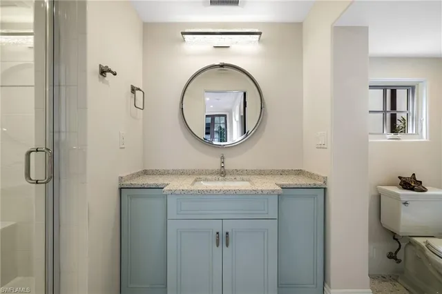 a bathroom with a granite countertop sink mirror and vanity