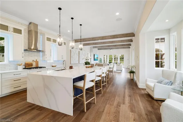 a kitchen with stainless steel appliances sink dining table and chairs