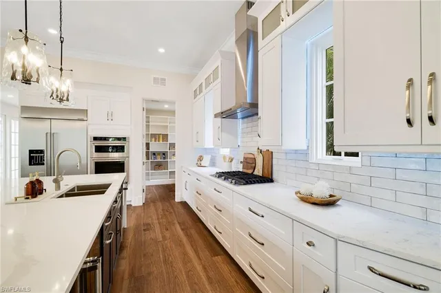 a kitchen with kitchen island granite countertop a sink stainless steel appliances and cabinets