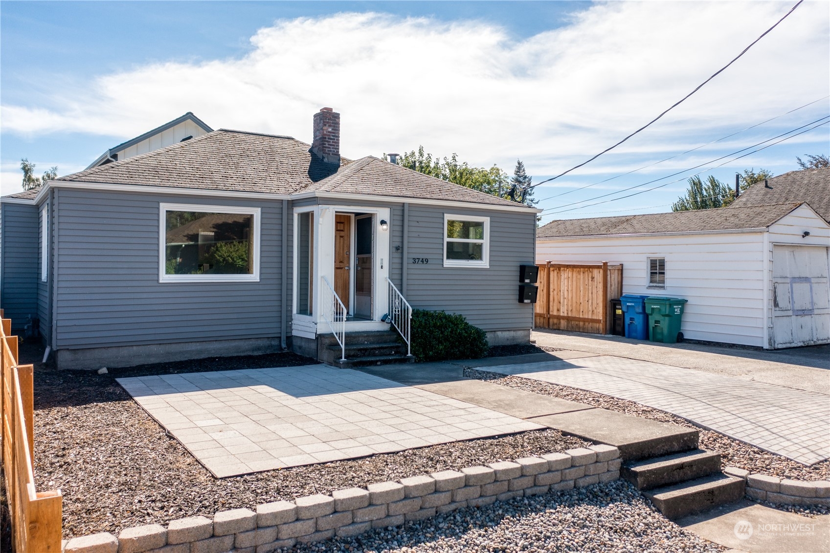 3749 Southwest Monroe Street Seattle, WA 98126 - Photo 2 of 25 a front view of a house with a yard and garage
