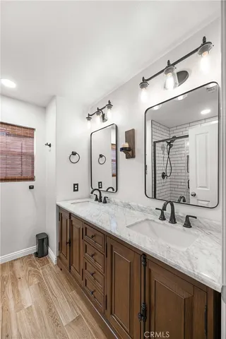 a bathroom with a granite countertop double vanity sink and mirror