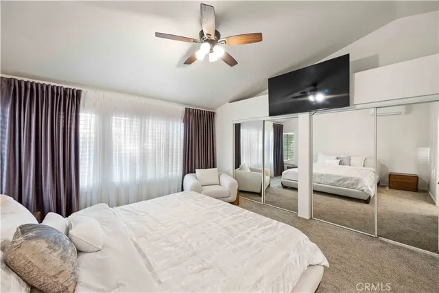 a bedroom with a large bed and a chandelier