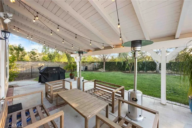 a view of a patio with a table chairs and a backyard