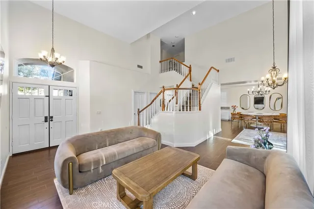 a living room with furniture a chandelier and wooden floor