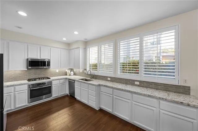 a kitchen with stainless steel appliances granite countertop a sink a stove a microwave a center island and cabinets