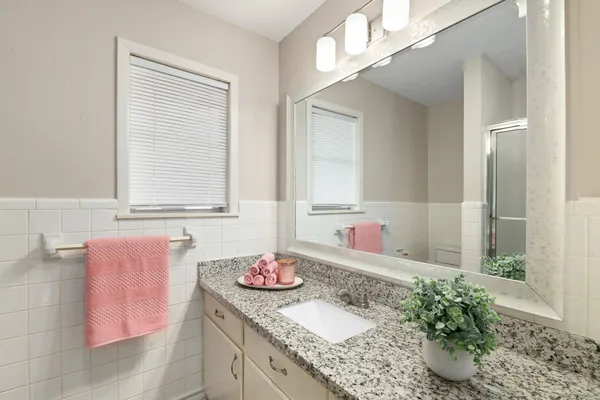 a bathroom with a granite countertop sink and a mirror