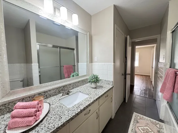 a bathroom with a granite countertop sink and a mirror